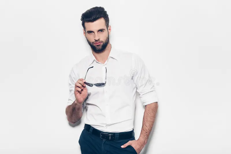 handsome stylish young man white shirt holding sunglasses looking camera standing against white background 73166066